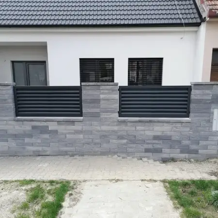 Hliníkový plot s horizontálnymi profilmi osadený v murovaných pilieroch